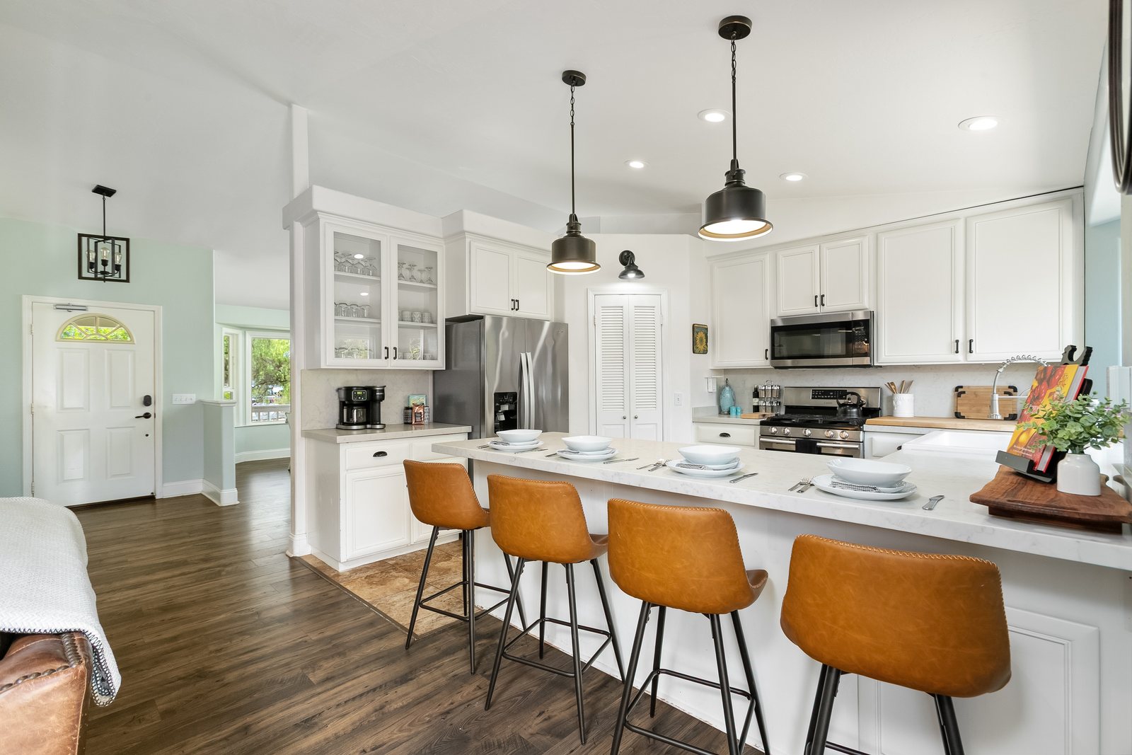 Open kitchen at Red Barn Ranch with a marble island and four leather bar stools.
